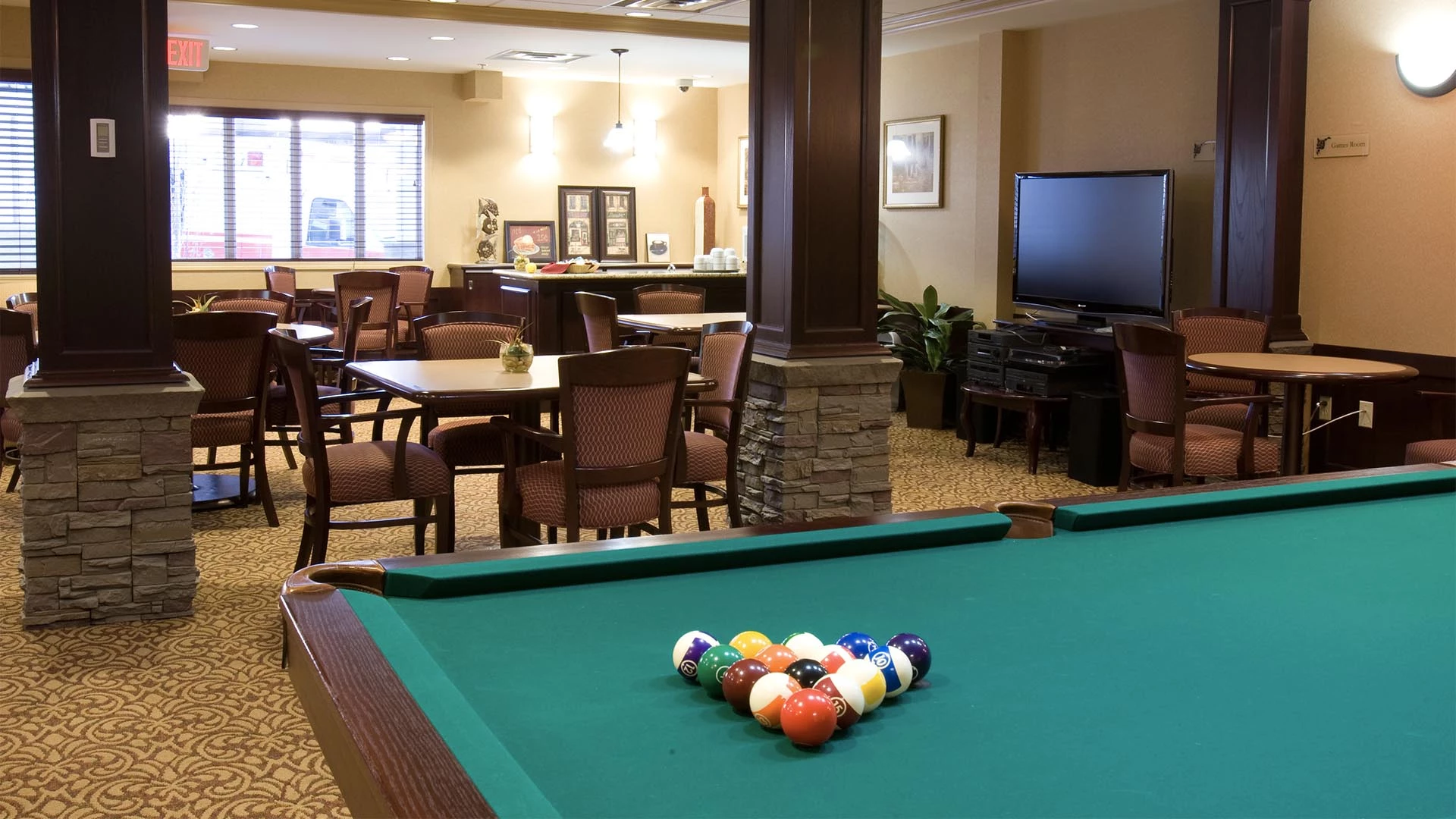 Game room with pool table and a TV in Summerwood Village senior living