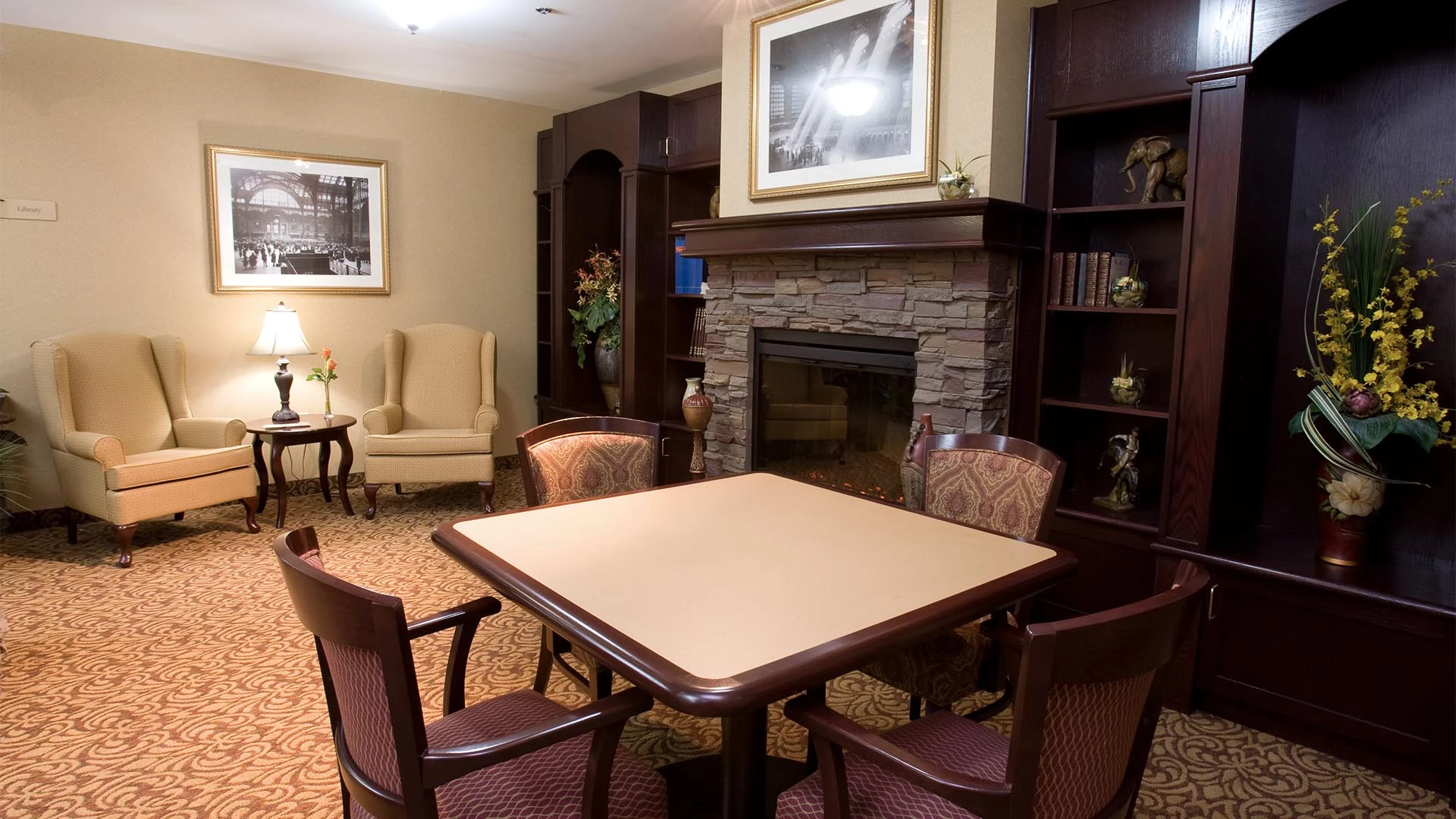 Sitting room with a table, chairs and a fireplace in Summerwood Village senior living