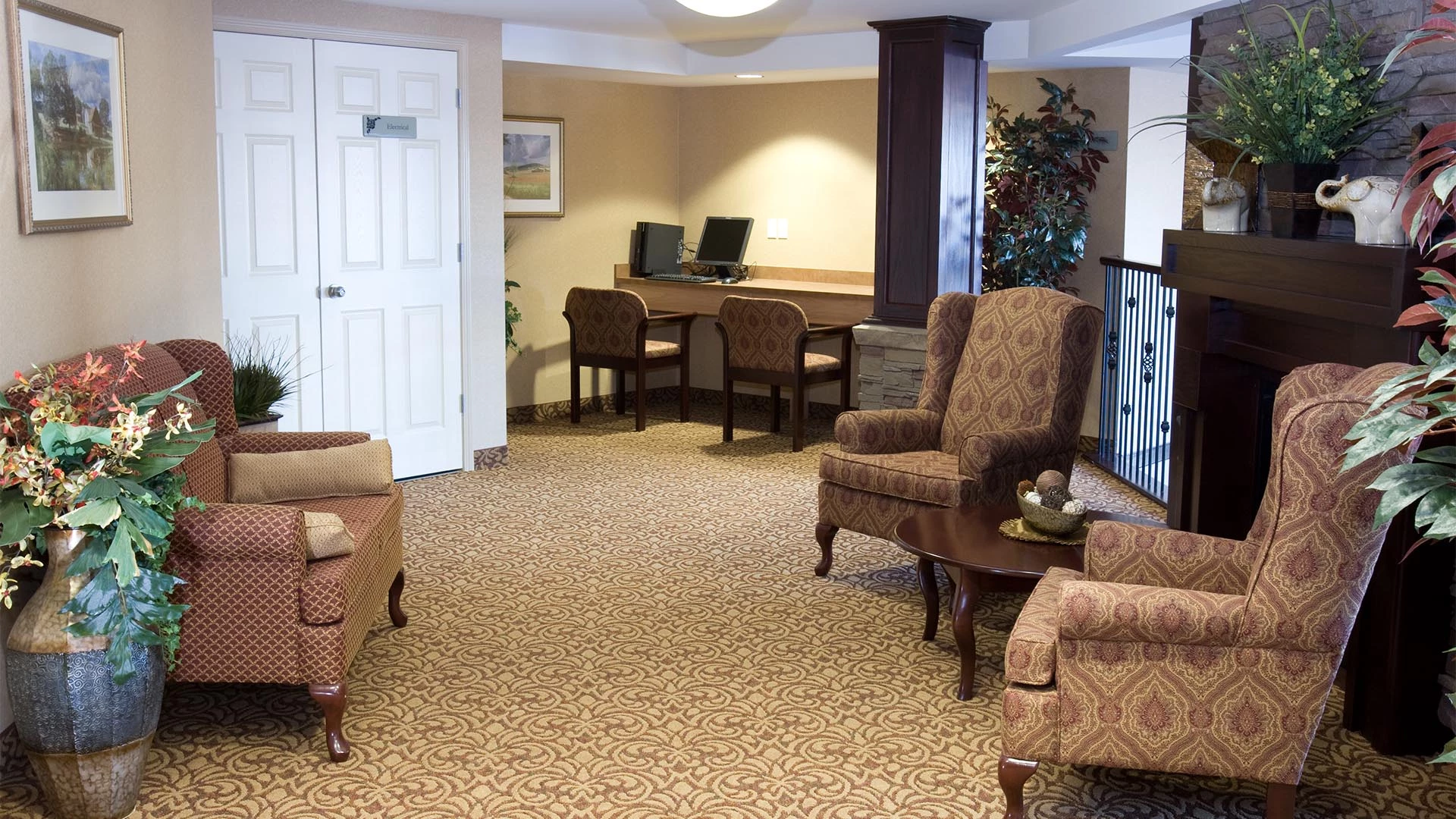 Sitting room with chairs and a computer at Summerwood Village retirement home